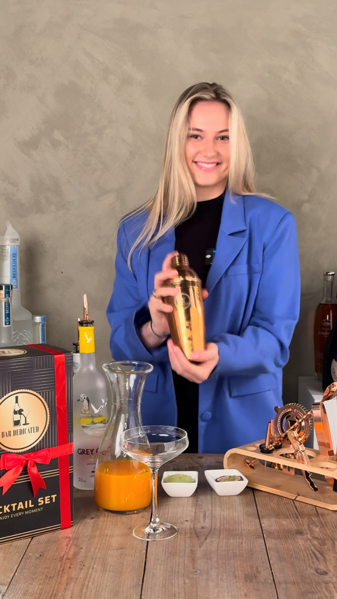Bar Dedicated cocktailshaker set – vrouw maakt cocktails met gouden shaker en luxe geschenkverpakking.